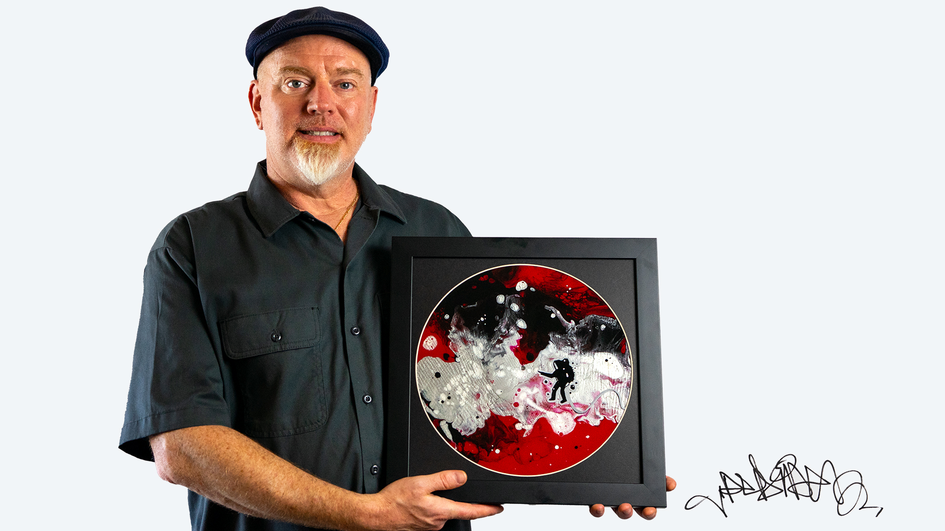 San Diego artist Redideo holding a vinyl record wall art piece from Volume 2.